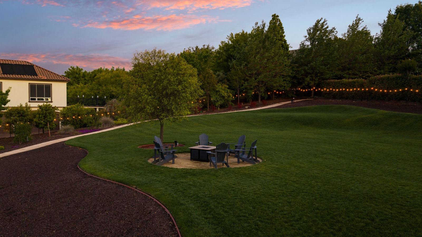 The lawn at dusk with firepit lounge